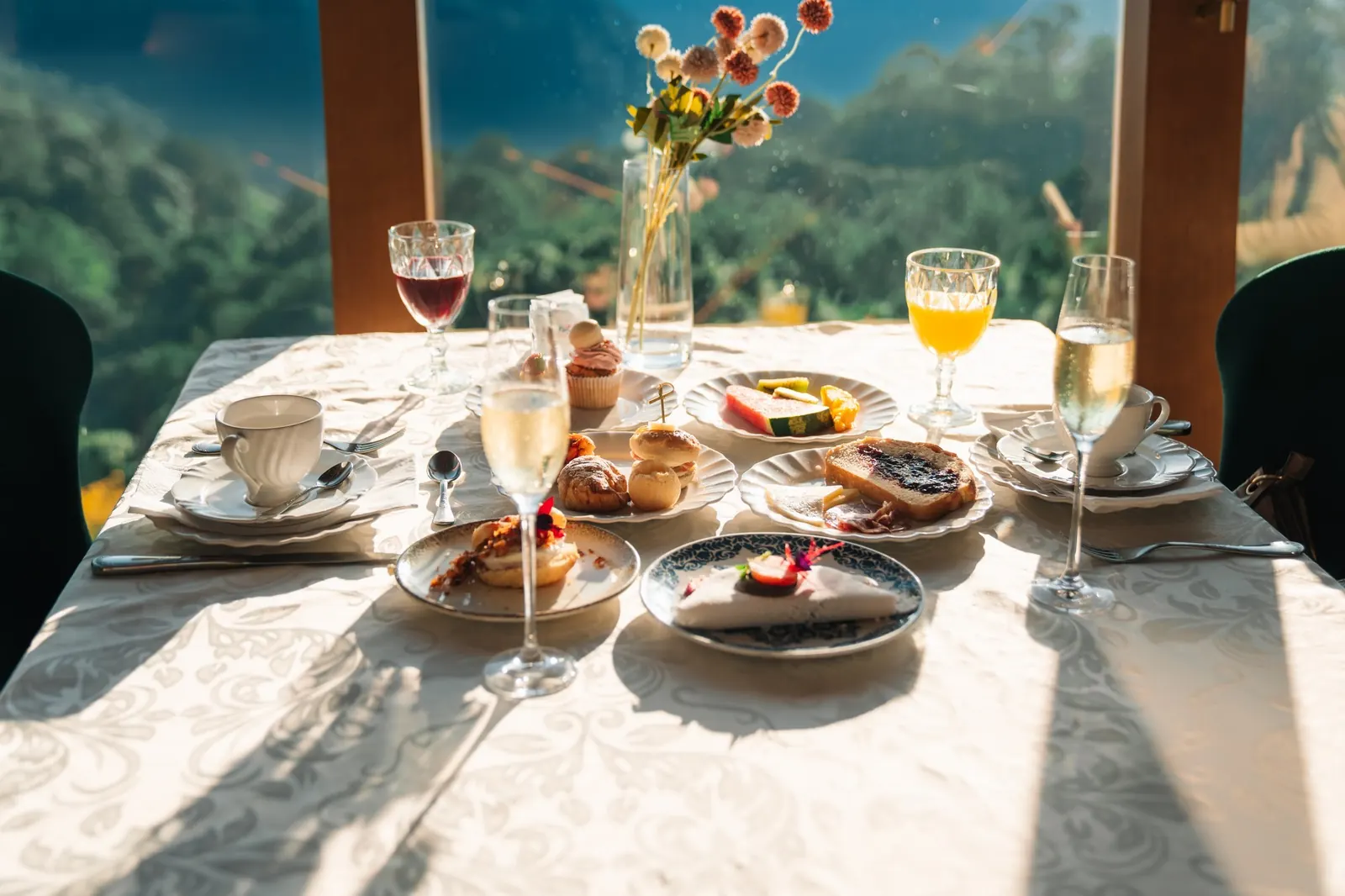 Mesa posta para o café da manhã, com a mata do vale pela janela
