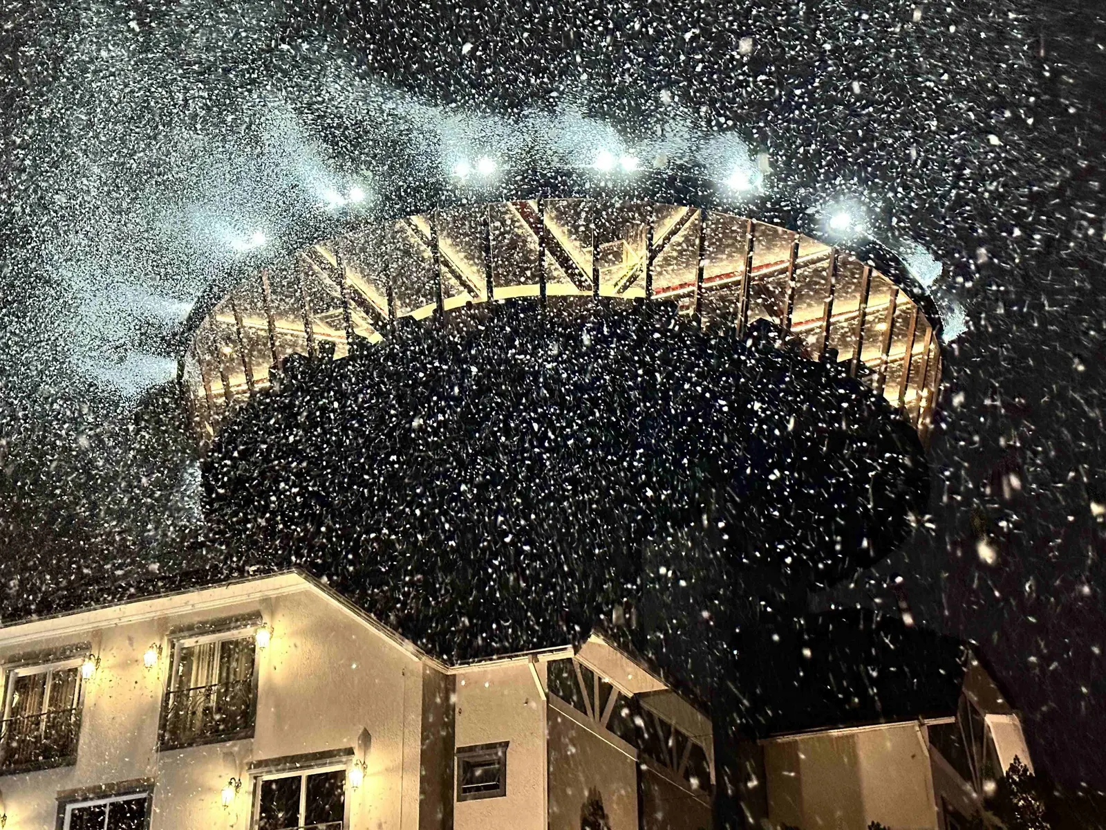 Neve caindo sobre a torre do restaurante à noite